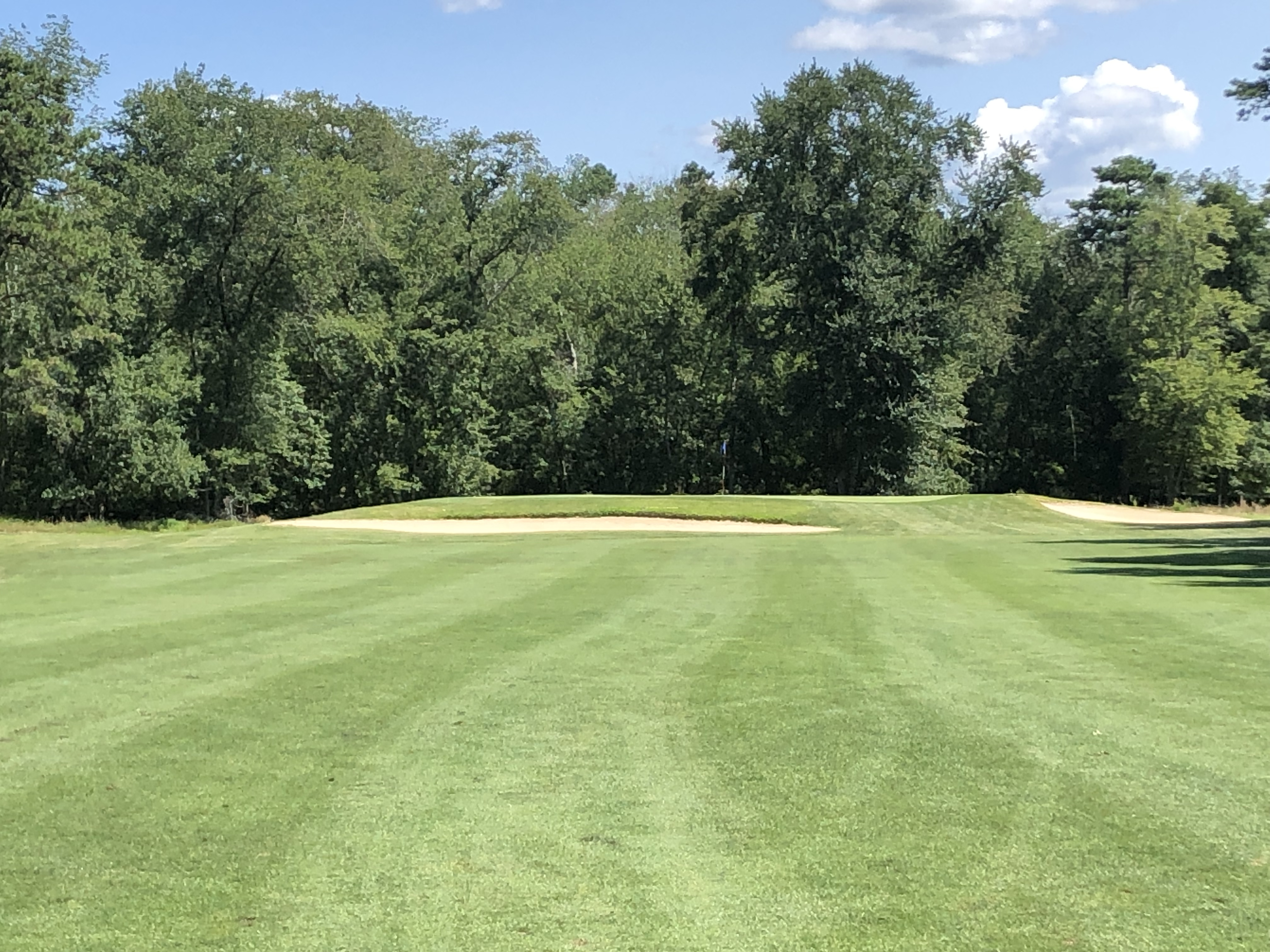 Hole 13 Fairway with the green and blue-colored flag in the distance.